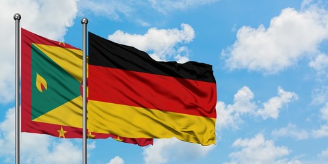 Grenada and Germany flag waving in the wind against white cloudy blue sky together. Diplomacy concept, international relations.