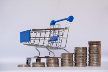 A small cart with a coin on a white background leading to growth to success, saving, saving concept