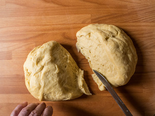 Woman cutting dough into pieces for further rolling and baking