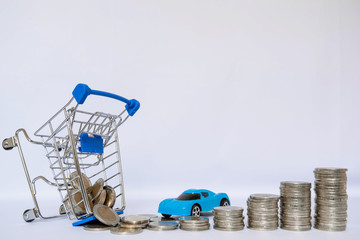A barrow small shopping cart with coins on a white background for economizing  buying cars Concept of economizing and buying cars