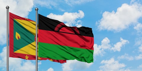 Grenada and Malawi flag waving in the wind against white cloudy blue sky together. Diplomacy concept, international relations.
