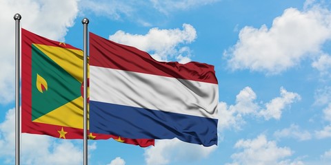 Grenada and Netherlands flag waving in the wind against white cloudy blue sky together. Diplomacy concept, international relations.