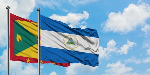 Grenada and Nicaragua flag waving in the wind against white cloudy blue sky together. Diplomacy concept, international relations.