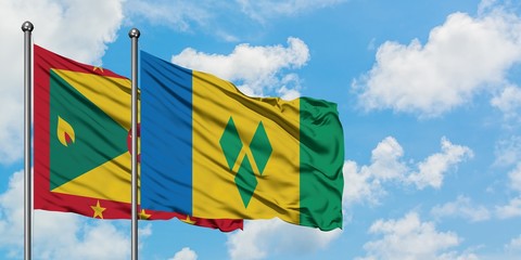Grenada and Saint Vincent And The Grenadines flag waving in the wind against white cloudy blue sky...