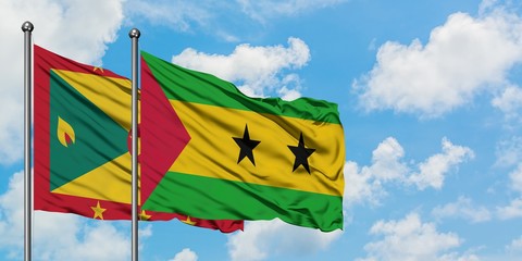 Grenada and Sao Tome And Principe flag waving in the wind against white cloudy blue sky together. Diplomacy concept, international relations.