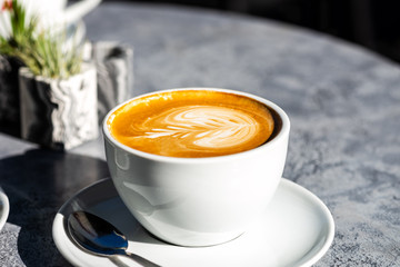 Flat white coffee on the table in the cafe