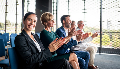 Happy audience applauding speaker at business conference