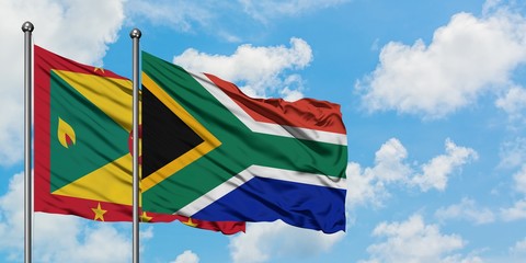 Grenada and South Africa flag waving in the wind against white cloudy blue sky together. Diplomacy concept, international relations.