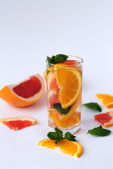Fototapeta na wymiar Detox citrus cocktail. healthy lifestyle. Fresh citrus fruit on white background. refreshing cocktail with slices of fresh orange and grapefruit with green mint leaves on white background.
