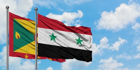 Grenada and Syria flag waving in the wind against white cloudy blue sky together. Diplomacy...