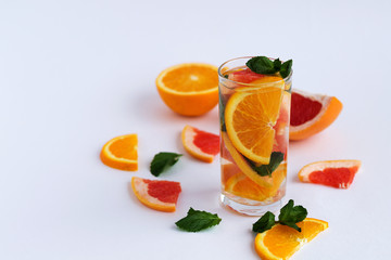 Fresh citrus fruit on white background. refreshing cocktail with slices of fresh orange and grapefruit with green mint leaves on white background. Detox citrus cocktail. healthy lifestyle. copy space