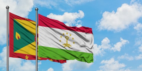 Grenada and Tajikistan flag waving in the wind against white cloudy blue sky together. Diplomacy concept, international relations.