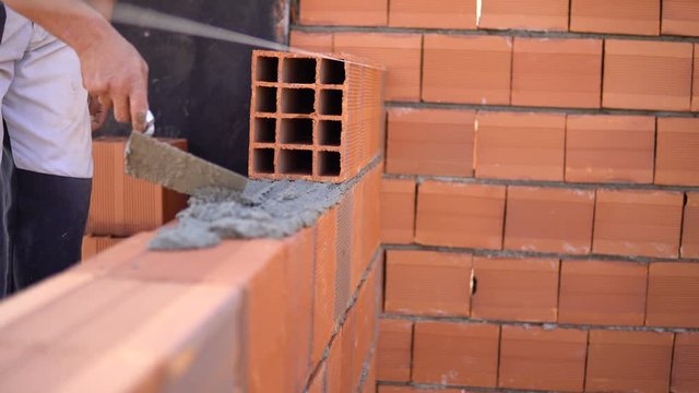 Construction worker laying bricks on exterior walls