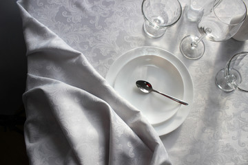 beautiful folds of white cloth on a table with utensils