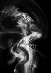 Conceptual monochrome black and white avant-garde portrait of a beautiful young girl covered with lines applied by a light brush. Art style creative photo. Advertising, fashion and commercial design.