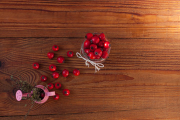 Immunity boosting treatments, infusions. Natural thyme, mint herbs and rosehip berries in a jar on a wooden background.