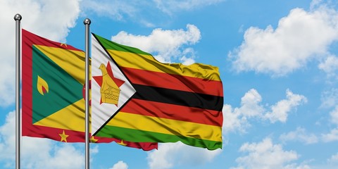 Grenada and Zimbabwe flag waving in the wind against white cloudy blue sky together. Diplomacy concept, international relations.