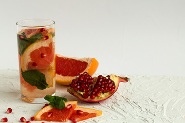 healthy lifestyle. Detox citrus cocktail. Refreshing summer homemade cocktail with grapefruit and pomegranate fruit on white background. copy space