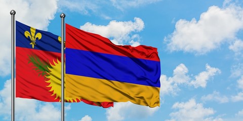 Guadeloupe and Armenia flag waving in the wind against white cloudy blue sky together. Diplomacy concept, international relations.