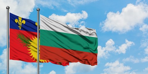 Guadeloupe and Bulgaria flag waving in the wind against white cloudy blue sky together. Diplomacy concept, international relations.