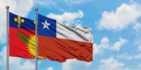 Guadeloupe and Chile flag waving in the wind against white cloudy blue sky together. Diplomacy concept, international relations.