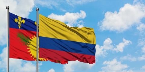 Guadeloupe and Colombia flag waving in the wind against white cloudy blue sky together. Diplomacy concept, international relations.