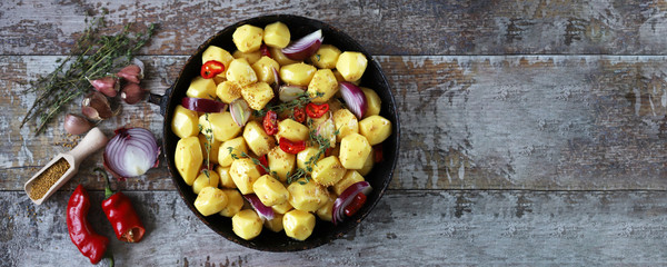 Raw potatoes in a pan with spices before baking. Vegan dinner or lunch.