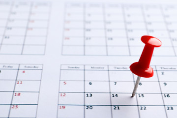 Red pin on the date 14th on the calendar close-up. Important date. Place for text. Planning concept.