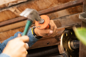 Human hand making holes using hole rolling gate puncher by hammer..