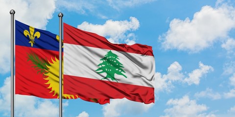 Guadeloupe and Lebanon flag waving in the wind against white cloudy blue sky together. Diplomacy concept, international relations.