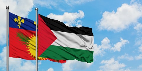 Guadeloupe and Palestine flag waving in the wind against white cloudy blue sky together. Diplomacy concept, international relations.