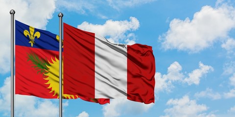 Guadeloupe and Peru flag waving in the wind against white cloudy blue sky together. Diplomacy concept, international relations.