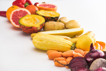 red onions, beetroots, carrots, potatoes, zucchini pumpkin and grapefruit on white background