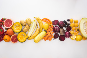 top view of assorted autumn vegetables, fruits and berries on white background