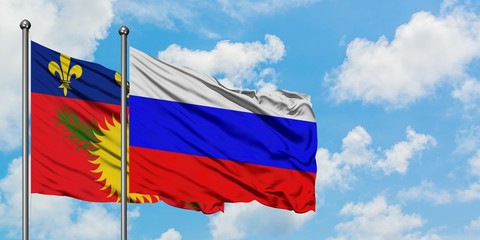 Guadeloupe and Russia flag waving in the wind against white cloudy blue sky together. Diplomacy concept, international relations.