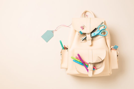 White backpack with school supplies and blank tag - education