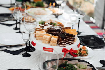 Serves dinner on a festive table. Food, Salads, Meat, Fish Meals. Festive table at wedding banquet. Decor. Details. Served tables at the Banquet. Drinks, snacks, delicacies. A gala event or wedding.