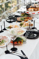 Restaurant table with food. Huge amount of food on the table. Plates of food. Dinner time, lunch. A table full of food in a restaurant. Festively served table at restaurant for a banquet.