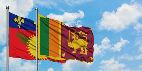 Guadeloupe and Sri Lanka flag waving in the wind against white cloudy blue sky together. Diplomacy concept, international relations.