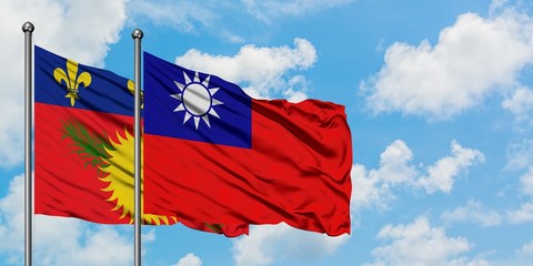 Guadeloupe and Taiwan flag waving in the wind against white cloudy blue sky together. Diplomacy concept, international relations.