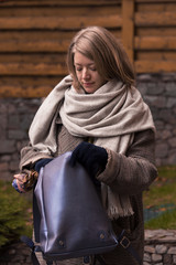 Blonde girl in a scarf and a checkered coat in autumn weather.