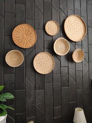  dark wall with decor. wicker plates. baskets on the wall.wicker plates on the wall