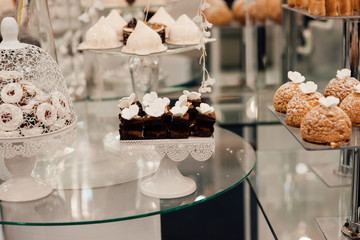 Luxury wedding catering, table with modern desserts, cupcakes. Delicious candy bar at expensive wedding reception. Holiday celebration