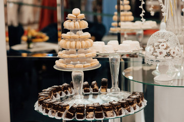 Candy bar for the wedding.Wedding decoration with pastel colored cupcakes, meringues, muffins and macarons. Elegant and luxurious event arrangement.  Luxury life.