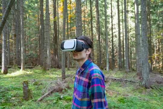 Young male with virtual reality  glasses  stand in the forest