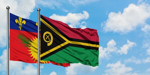 Guadeloupe and Vanuatu flag waving in the wind against white cloudy blue sky together. Diplomacy concept, international relations.