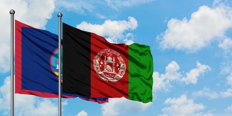 Guam and Afghanistan flag waving in the wind against white cloudy blue sky together. Diplomacy concept, international relations.