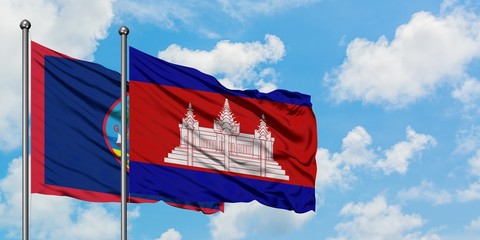 Guam and Cambodia flag waving in the wind against white cloudy blue sky together. Diplomacy concept, international relations.
