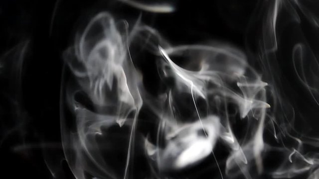 Beautiful smoke on a black background. Smoky texture. Steam rises.