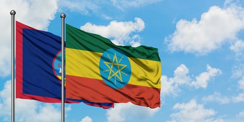 Guam and Ethiopia flag waving in the wind against white cloudy blue sky together. Diplomacy concept, international relations.